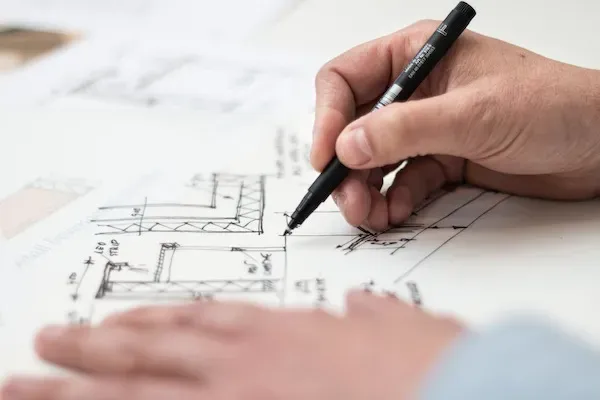 Person drawing a blueprint diagram